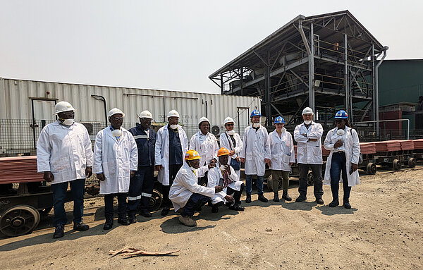 Mopani Kupfermine 12 Personen in weißem Kittel stehen vor einer Kupfermine