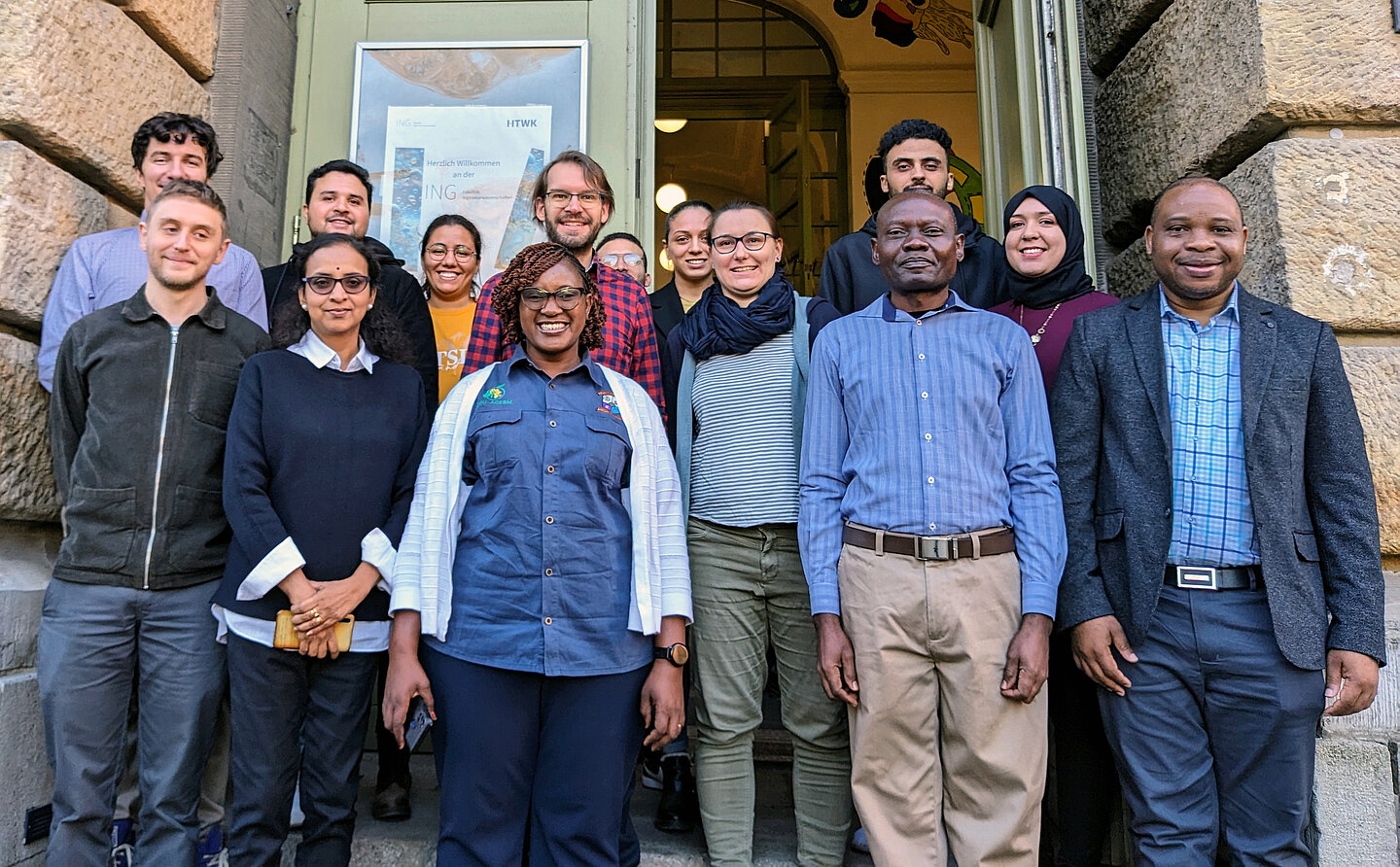 Besuch aus Sambia mehrere Personen stehen am Eingang des Wiener-Baus