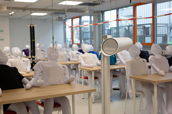 Klassenzimmer-Reallabor In einem Klassenraum sitzen aufblasbare Puppen mit T-Shirts an Tischen