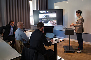 ein Mann hält vor Publikum einen Vortrag