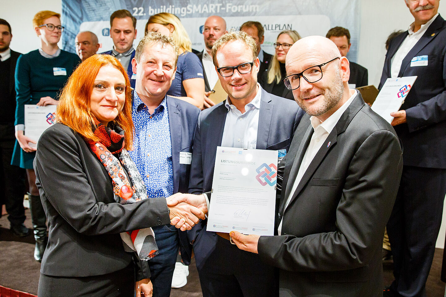 Prof. Dr. Monica Rossi, Prof. Henning Rambow und Timo Kretschmer (v.l.) von der HTWK Leipzig nehmen die Listungsurkunde in Empfang.  Ganz rechts: Gunther Wölfle, Geschäftsführer buildingSMART Deutschland. (Foto: buildingSMART Deutschland)