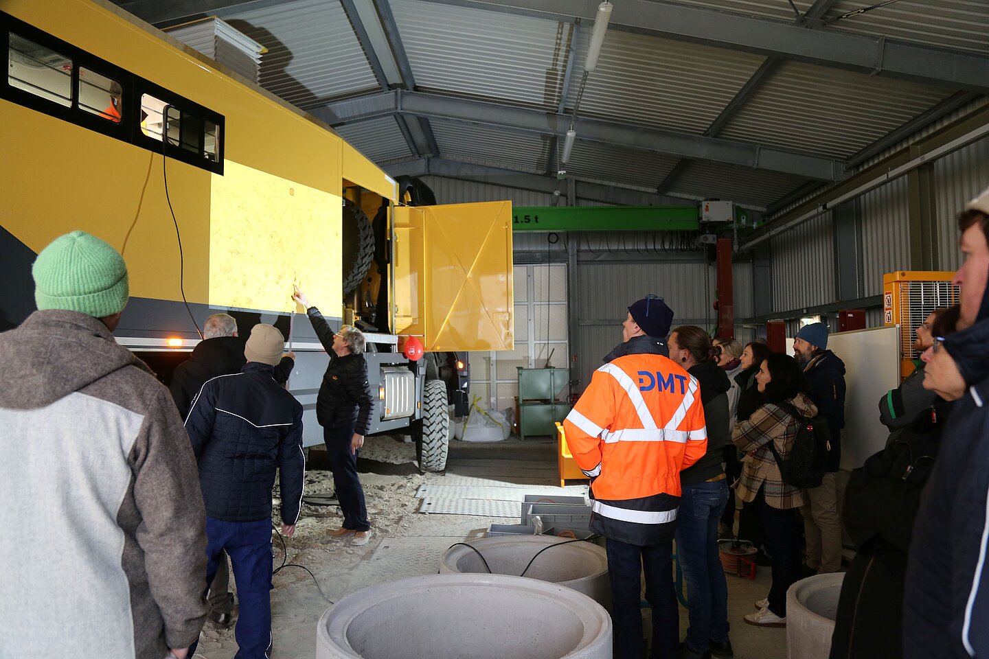 Teilnehmer betrachten die Videoprojektion am LKW und hören den Ausführungen des Referenten zu