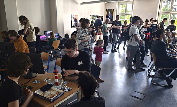 Viele Menschen in Seminarraum spielen zusammen verschiedene Spiele