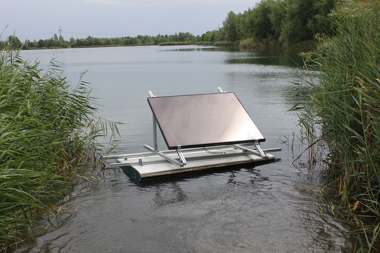 Foto von umfunktionierten Rotorblatt als Schwimmsegment mit einem darauf befestigten Photovoltaik-Panel auf einem See schwimmend